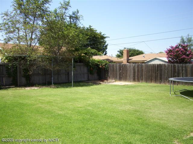 5108 South Bonham Street Amarillo, TX 79110 - Photo 12 of 13 a view of a backyard with table and chairs a barbeque and a large trees