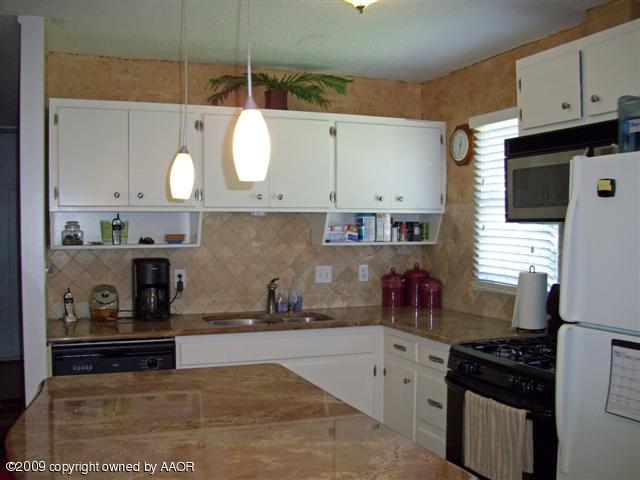 5108 South Bonham Street Amarillo, TX 79110 - Photo 5 of 13 a kitchen with stainless steel appliances granite countertop a stove a sink and a microwave