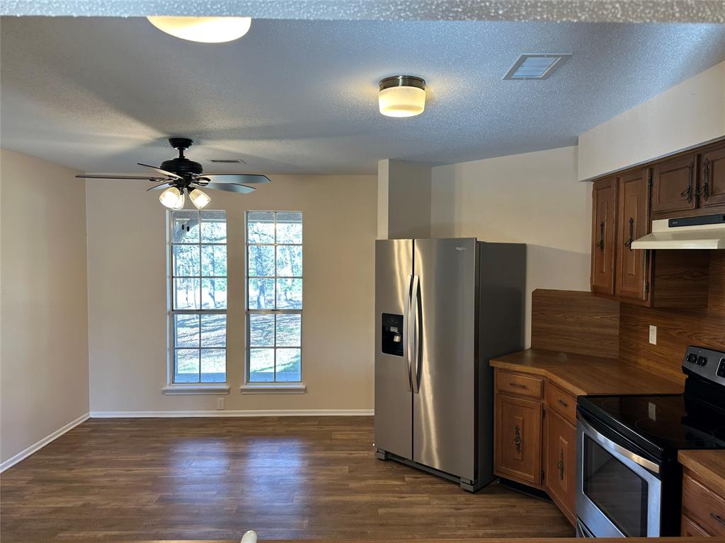 1047 Pr 3022 Elgin Elgin, TX 78621 - Photo 5 of 21 Kitchen featuring stainless steel appliances, dark wood-type flooring, a ceiling fan, and wood finish cabinetry