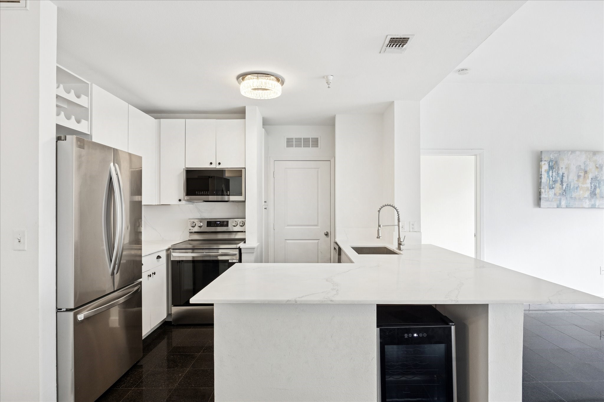 3505 Sage Road, Unit 1106 Houston, TX 77056 - Photo 7 of 22 The kitchen is outfitted with polished quartz countertops, streamlined cabinetry, and stainless steel appliances, offering both refined style and everyday functionality.