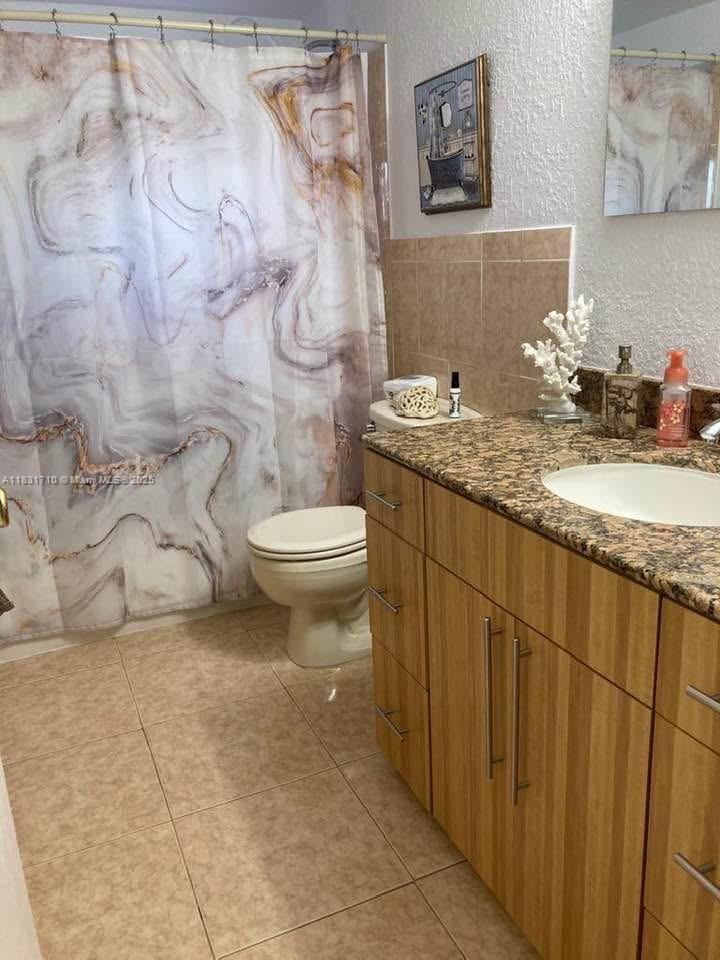 2160 Southwest 16th Avenue, Unit 421 Miami, FL 33145 - Photo 16 of 19 a bathroom with a granite countertop sink a toilet and a mirror