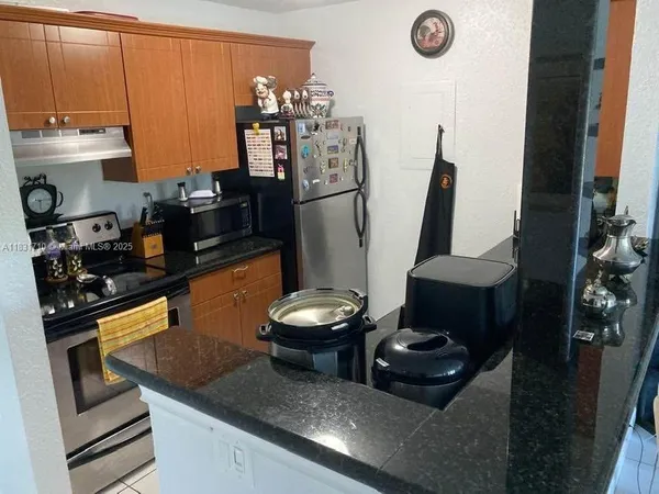 a kitchen with stainless steel appliances granite countertop a sink dishwasher stove and refrigerator