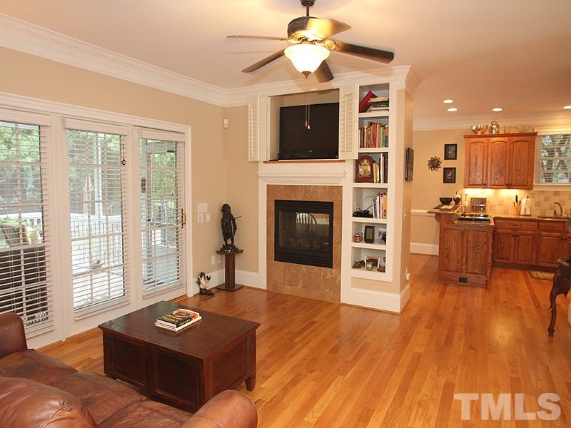 3710 Congeniality Way Raleigh, NC 27613 - Photo 8 of 23 2-way fireplace, built-in shelves and TV niche, hardwoods, crown molding, and French doors to the screened porch grace this beautiful room.