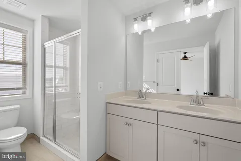 a bathroom with a granite countertop sink a toilet and a mirror