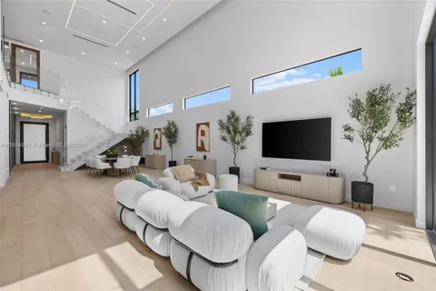 a large white kitchen with a large window and stainless steel appliances