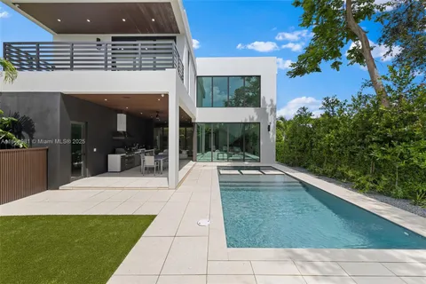 a view of a hallway with wooden floor and a living room