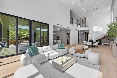 a living room with furniture large windows and a fireplace