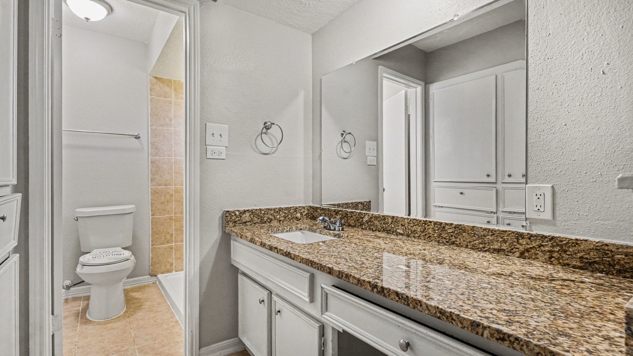 23210 Earlmist Drive Spring, TX 77373 - Photo 16 of 22 a bathroom with a granite countertop sink a toilet and a shower