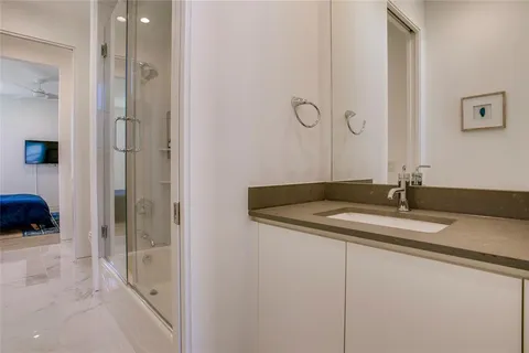 a en suite bathroom with a granite countertop sink and a mirror
