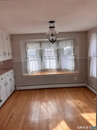 a view of a hallway with wooden floor and closet