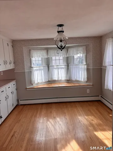 a view of a hallway with wooden floor and closet