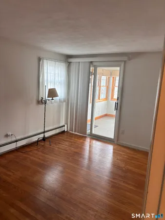 an empty room with wooden floor and windows in it