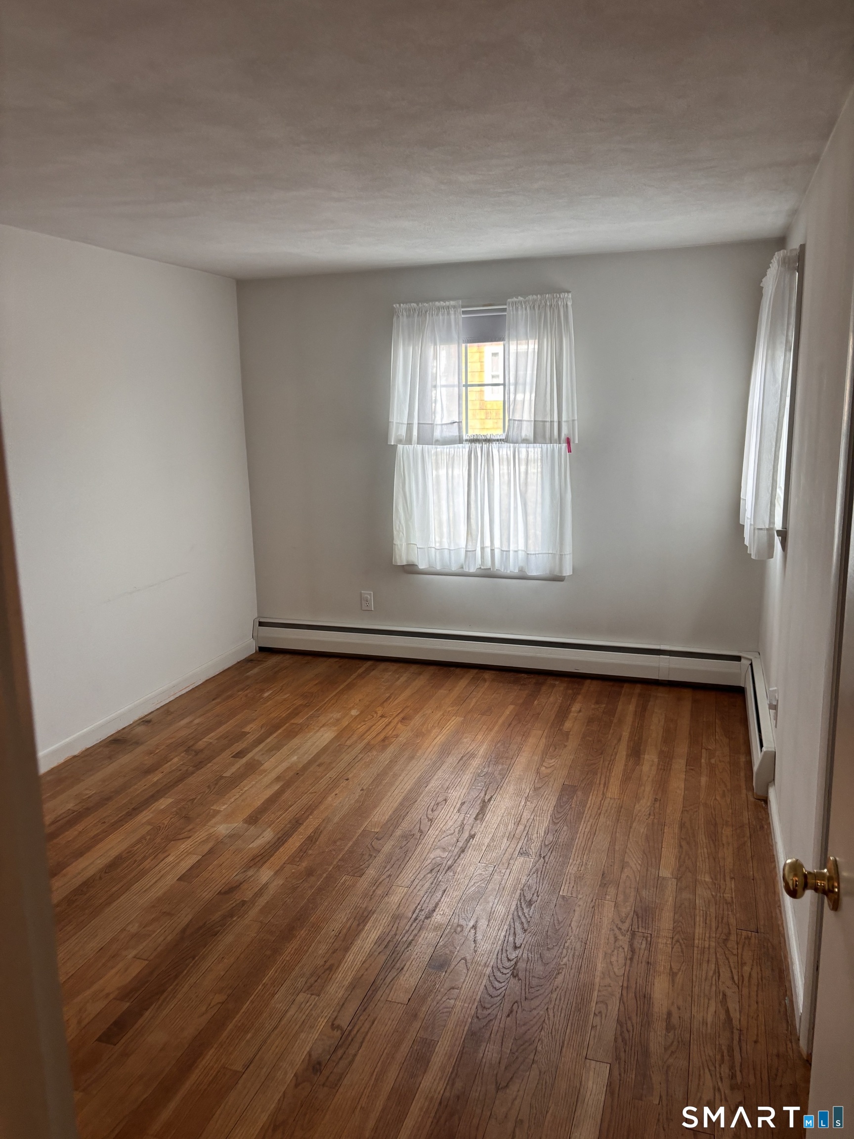28 Bayberry Lane Groton, CT 06340 - Photo 10 of 17 an empty room with wooden floor and windows