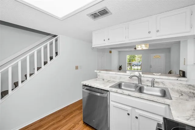 a kitchen with granite countertop a refrigerator and a sink