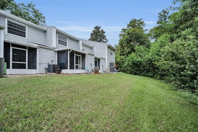 a view of a swimming pool with lawn chairs & wooden fence