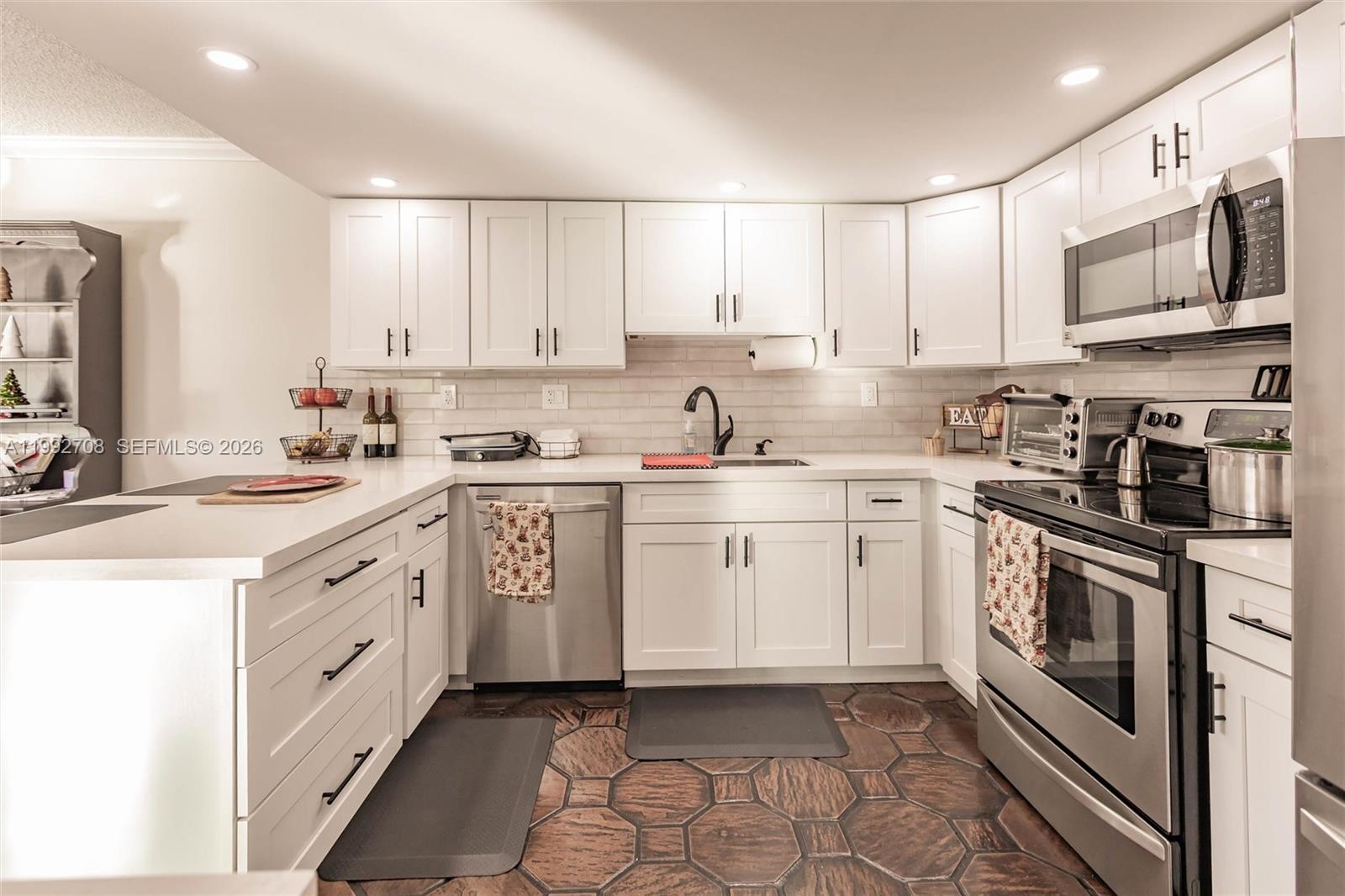 9404 Southwest 8th Terrace, Unit 9404 Miami, FL 33174 - Photo 21 of 41 a kitchen with white cabinets sink and stainless steel appliances