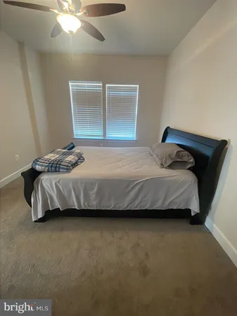 a bedroom with a bed and a ceiling fan