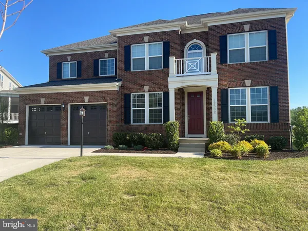 front view of a brick house with a yard