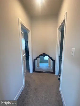 a view of a hallway with wooden floor and a living room