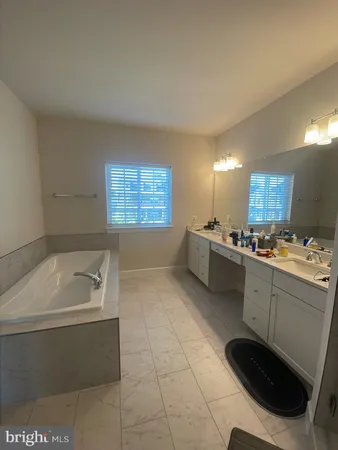 a bathroom with a tub sink and mirror