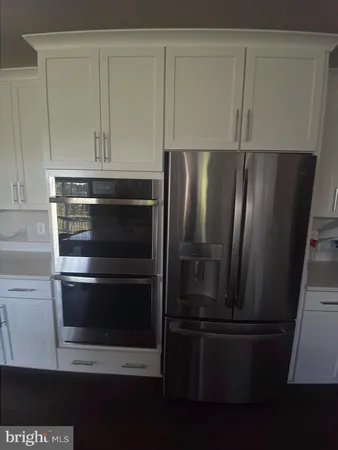 a metallic refrigerator freezer sitting in a kitchen