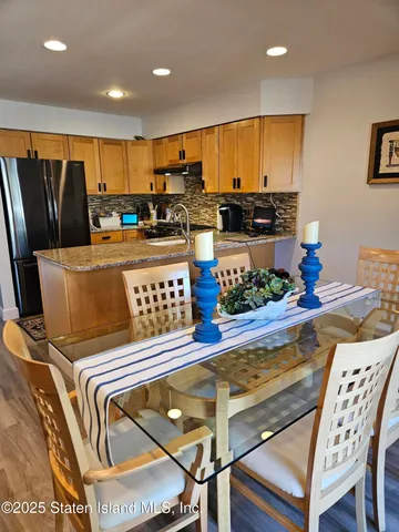 a living room with stainless steel appliances furniture and a kitchen view