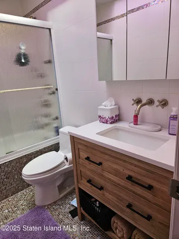 a bathroom with a granite countertop toilet a sink and a mirror