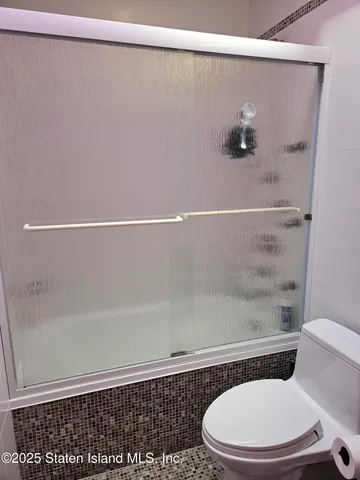 a bathroom with a toilet and a shower