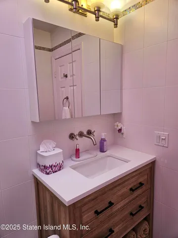 a bathroom with a sink vanity and a mirror