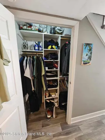 a view of walk in closet with clothes and shoes