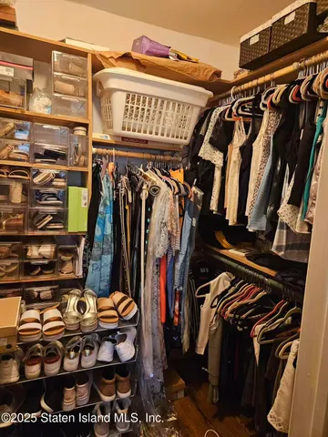 a view of walk in closet with clothes and shoes