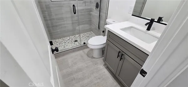 a bathroom with a granite countertop toilet a sink and a shower