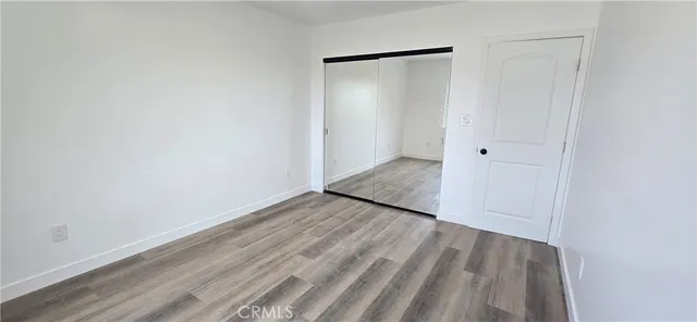 a view of a room with wooden floor and a hallway