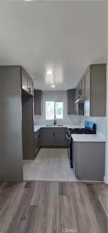 a view of a kitchen with a sink and a refrigerator