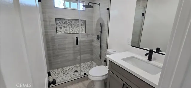 a bathroom with a sink a toilet and shower