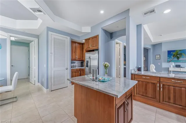 a kitchen with kitchen island granite countertop a sink and refrigerator