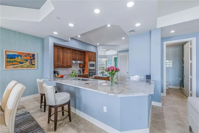 a room with kitchen island granite countertop furniture and a large window