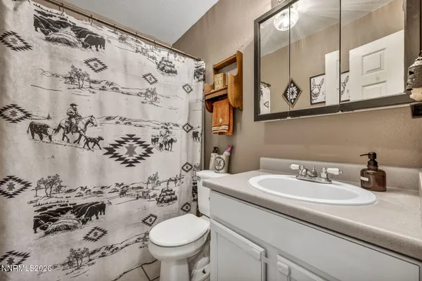 a bathroom with a sink and mirror with toilet