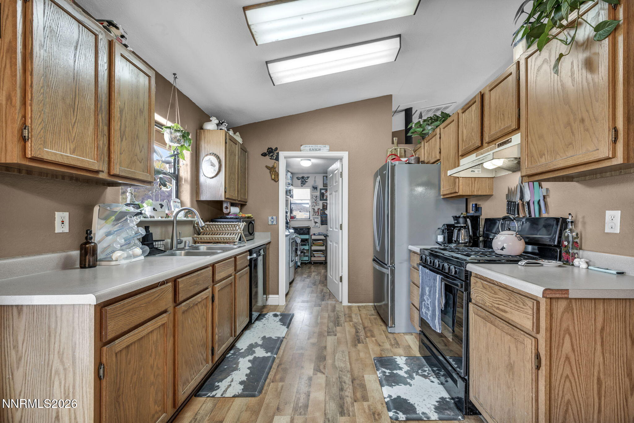 55 Buckboard Circle Reno, NV 89508 - Photo 10 of 39 a kitchen with stainless steel appliances granite countertop lots of counter top space a sink a stove and a refrigerator
