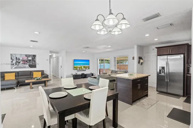 a view of a dining room with furniture a chandelier and wooden floor