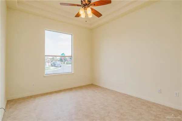 an empty room with a window and a fan
