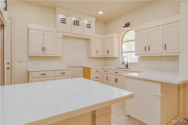 a kitchen with stainless steel appliances granite countertop a sink a stove and white cabinets