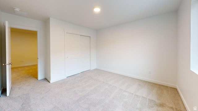 777 Pheasantbrook Drive, Unit 2B Centerville, UT 84014 - Photo 23 of 42 Carpeted interior space featuring white walls, a single window, an open doorway, and a closet with sliding panel doors
