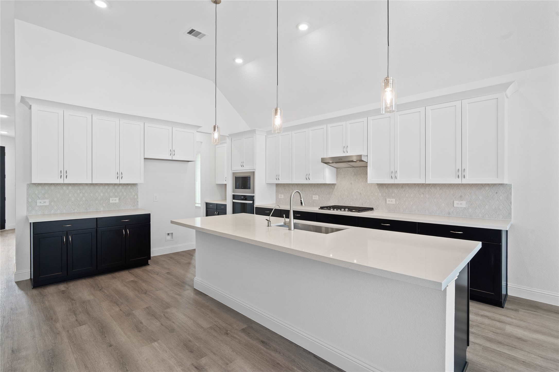 17315 July Moon Lane Conroe, TX 77302 - Photo 15 of 46 Pristine and functional, the central kitchen island provides both a focal point and practical prep space in this modern gourmet kitchen.