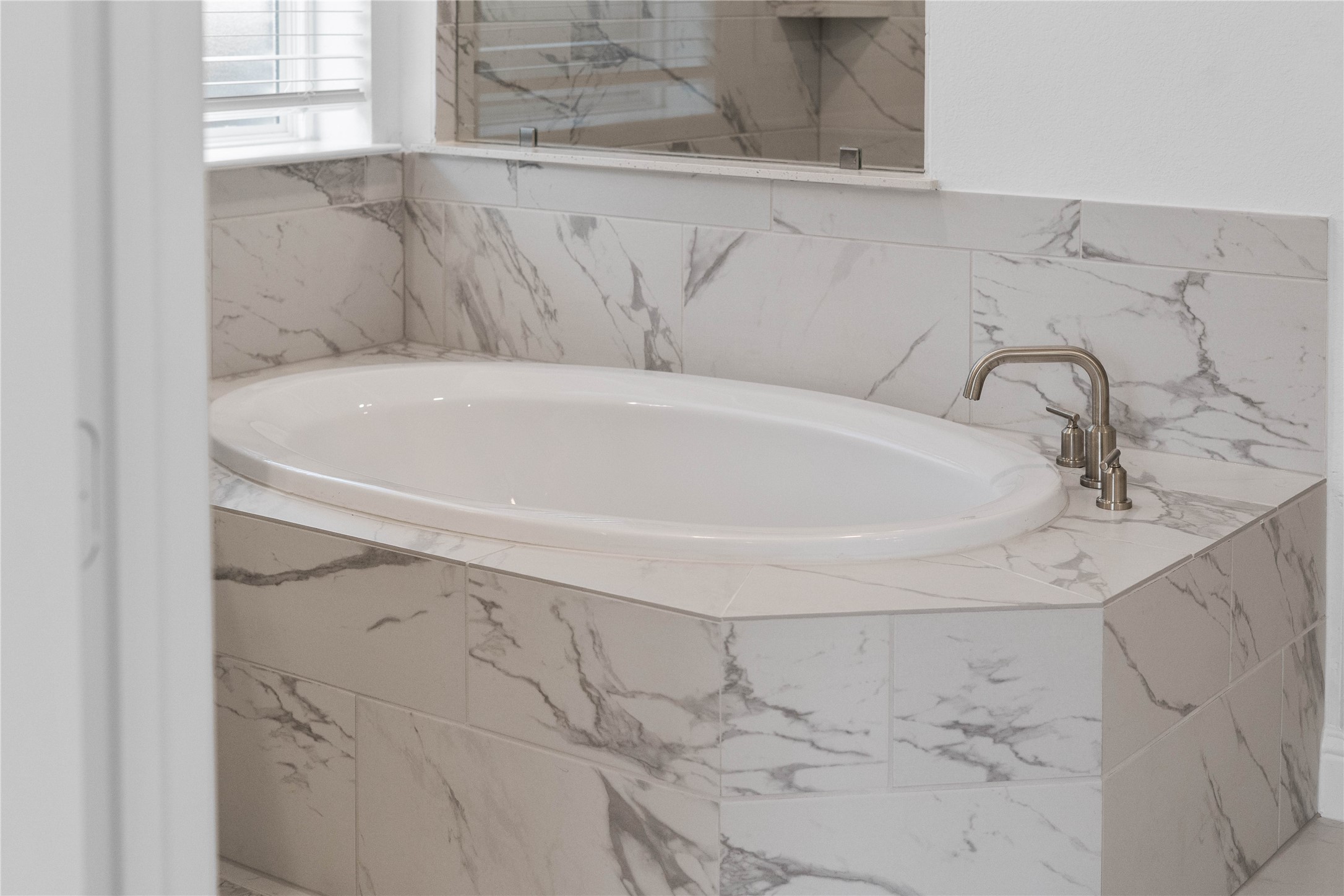 17315 July Moon Lane Conroe, TX 77302 - Photo 27 of 46 Unwind after a long day in the deep, corner soaking tub, a perfect sanctuary for relaxation. The tub is accented by stylish, warm-toned fixtures.