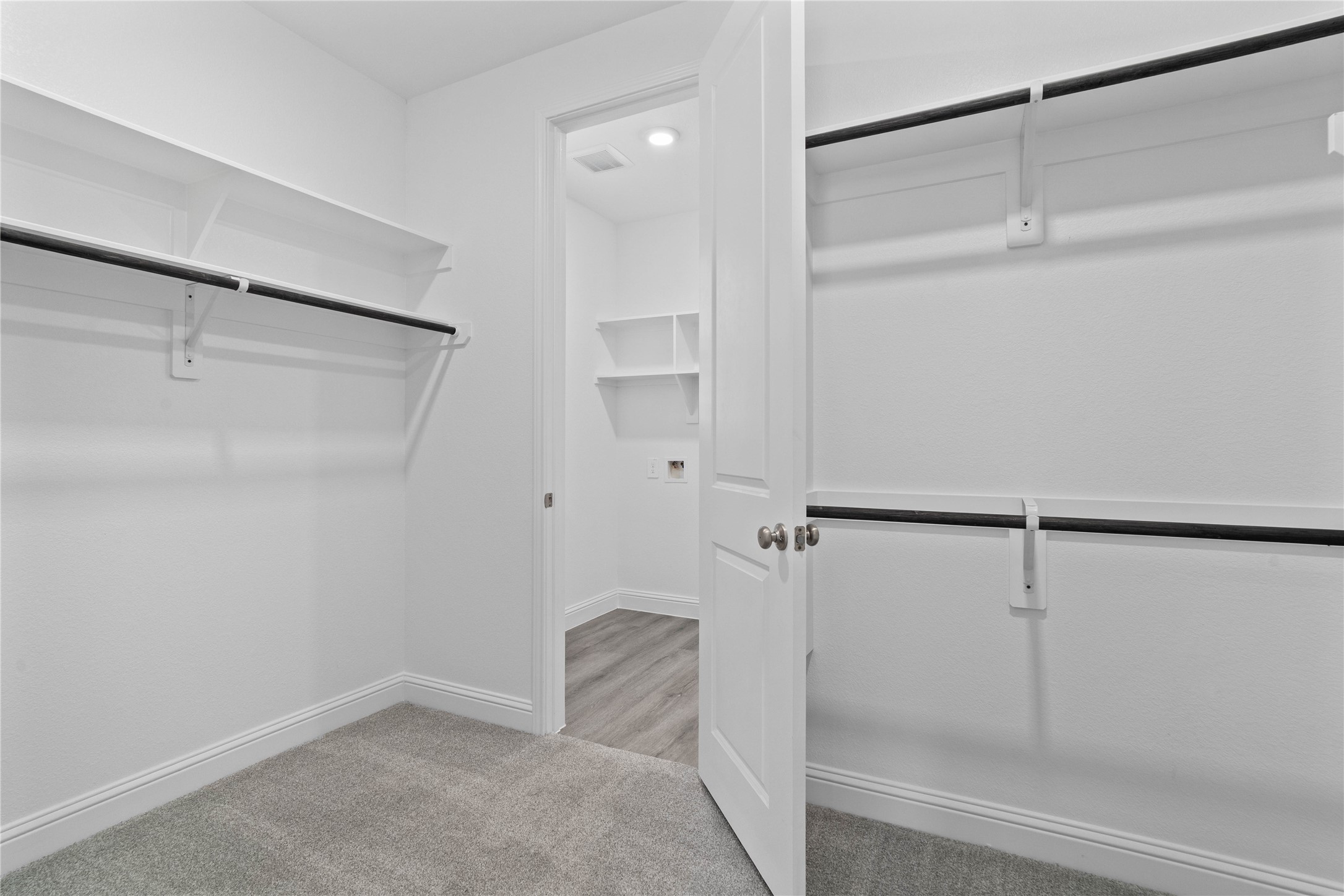 17315 July Moon Lane Conroe, TX 77302 - Photo 29 of 46 Look at this immaculate closet! With high shelving, multiple rows to hang clothing, you are sure to have enough room for all your belongings! Additional feature is the easy access into the laundry room from primary walk-in closet.