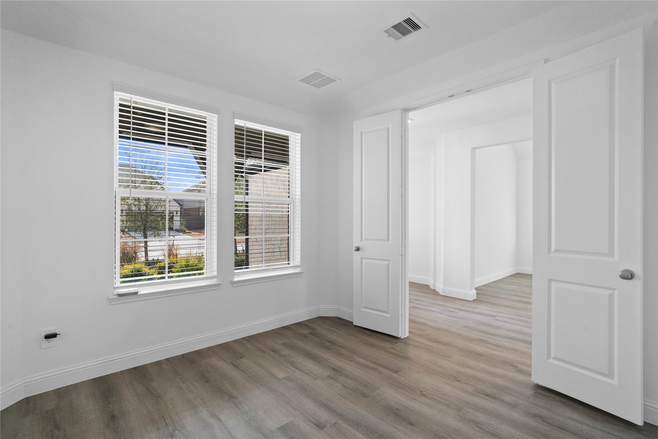 17315 July Moon Lane Conroe, TX 77302 - Photo 8 of 46 a view of an empty room with wooden floor and a window