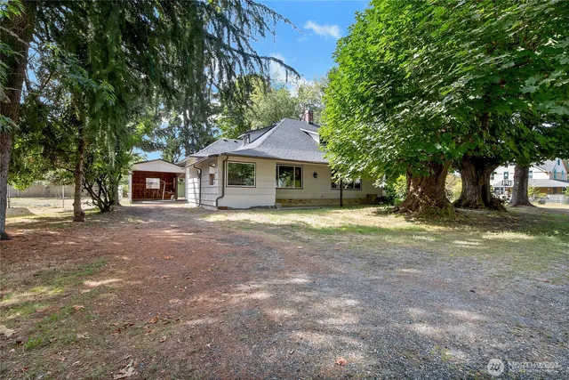 a front view of a house with a yard and trees