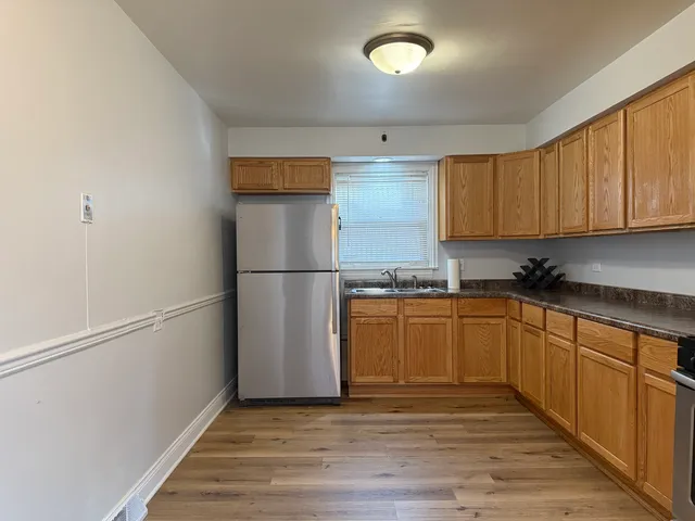 a kitchen with granite countertop a refrigerator and a sink