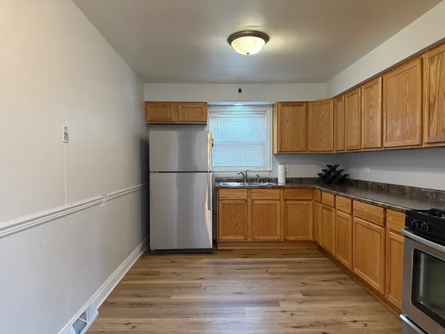a kitchen with a refrigerator and a stove top oven